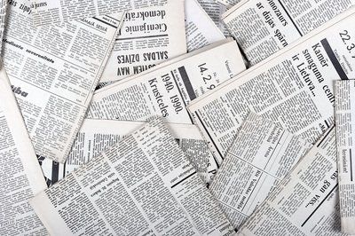 A bunch of old newspapers are stacked on top of each other