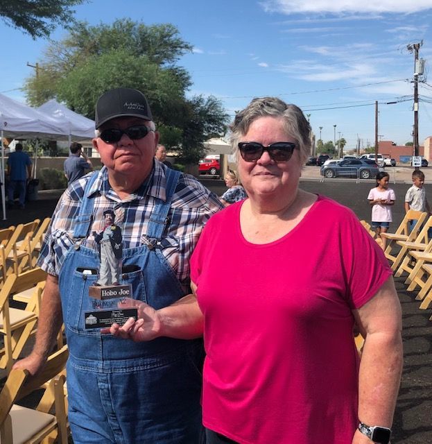 A man and woman standing next to each other holding a trophy
