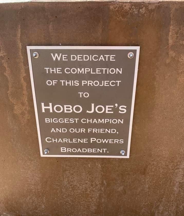 A sign that says we dedicate the completion of this project to hobo joe 's