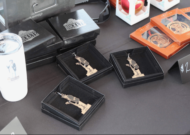 A table with boxes of jewelry and a cup that says ' buckeye ' on it