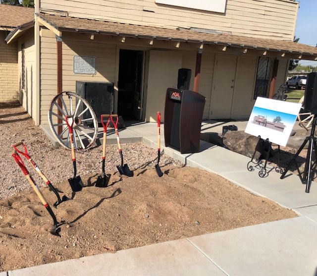 Shovels and a wagon wheel in front of a building