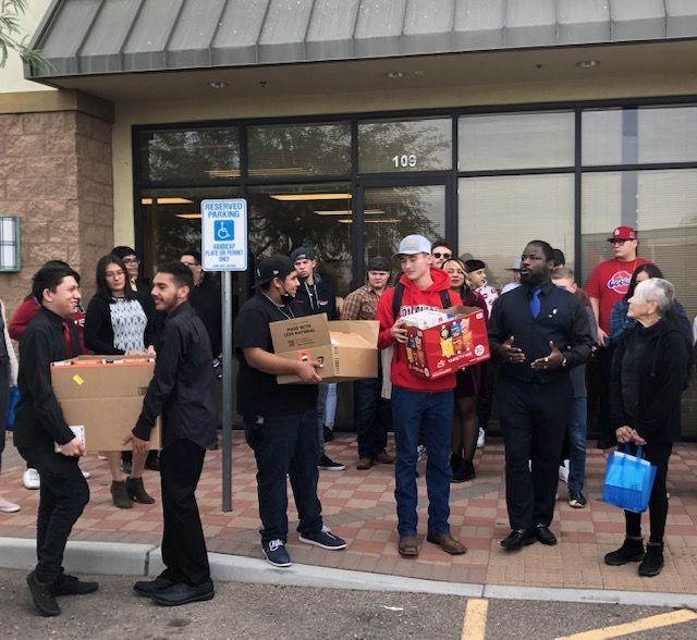 A group of people standing in front of a handicapped parking sign
