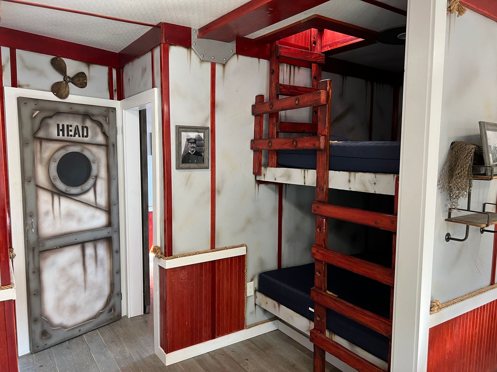 Red and white room with bunk beds, a door marked 