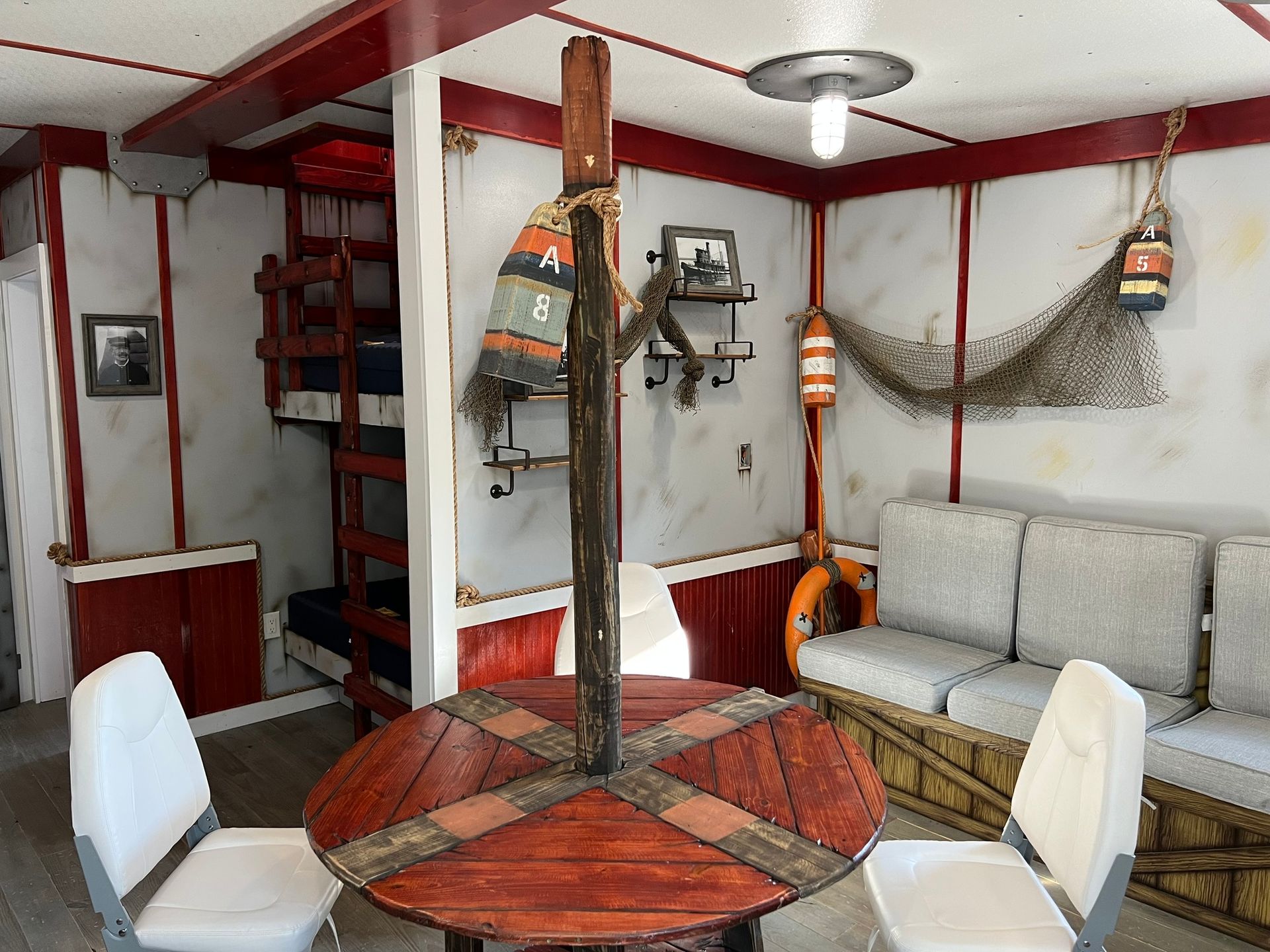 Interior of a nautical-themed room with a wooden table, seating, and fishing-related decor.