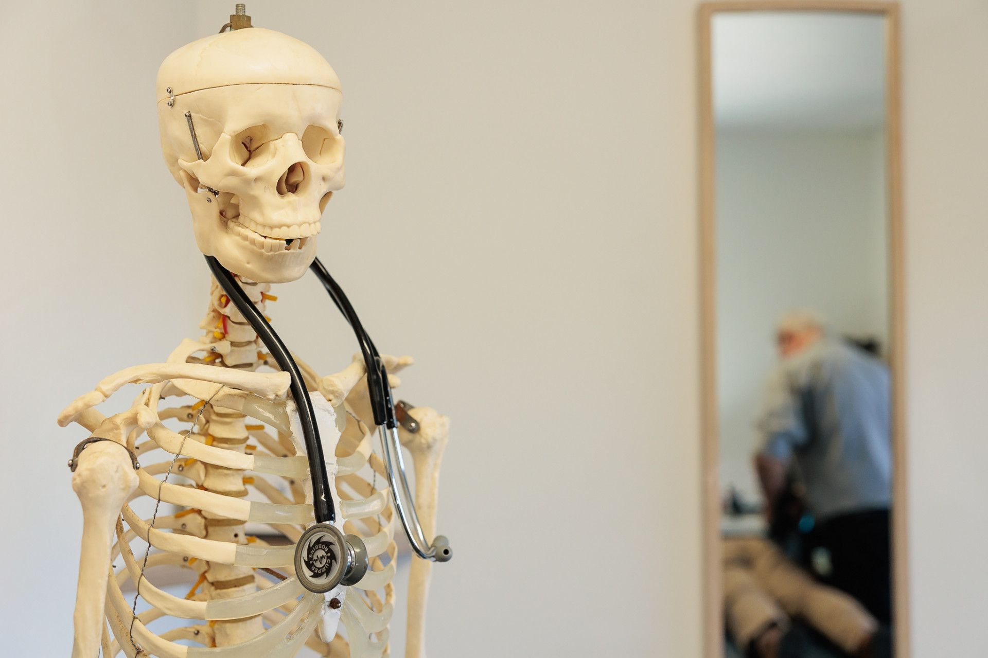 Skeleton with Stethoscope; Mirror Reflects a Person in The Background — Grays Chiropractic & Wellness In Ooralea, QLD