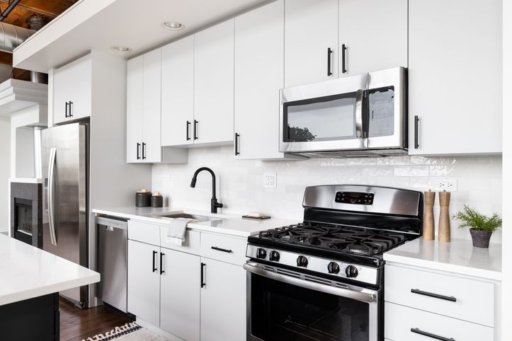 A white kitchen with stainless steel appliances.