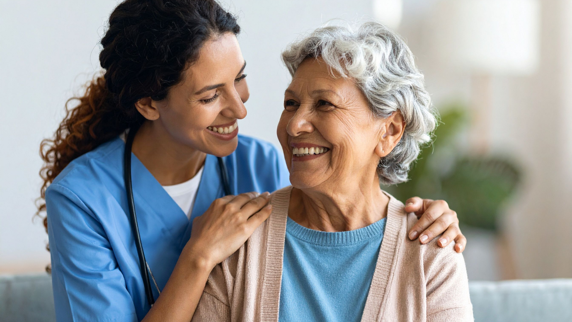 Nurse smiling and talking with an older woman in a bright home setting