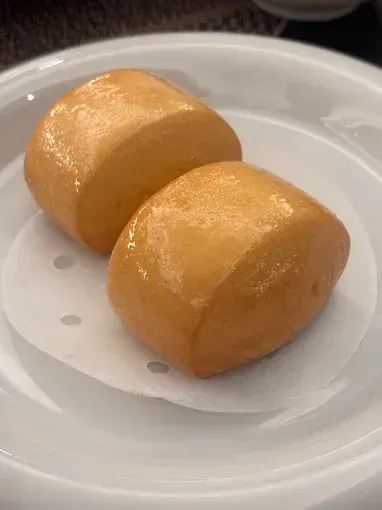 Due panini dorati su un piatto bianco con un tovagliolino di carta
