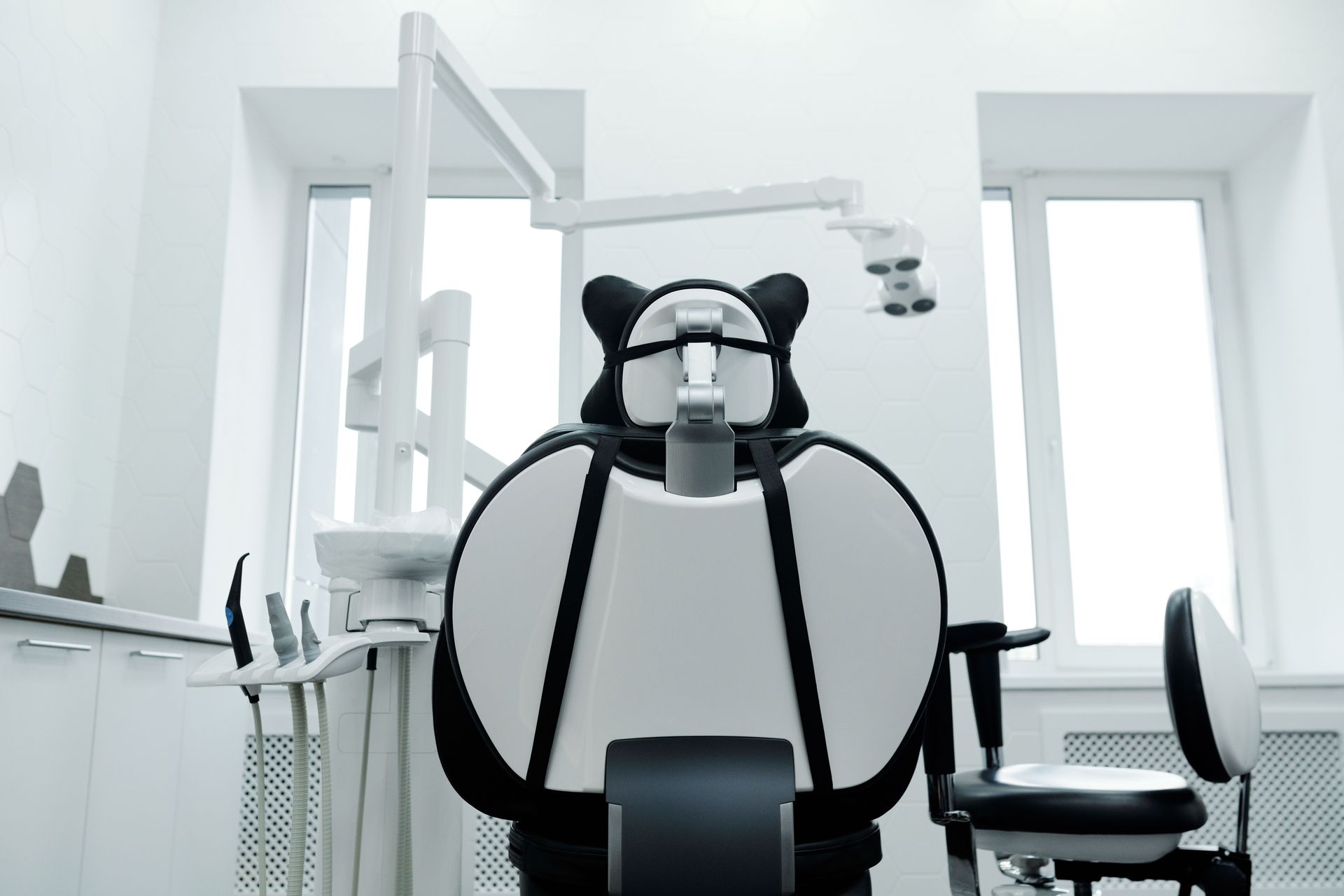Empty dental clinic with a black-and-white dental chair in the center