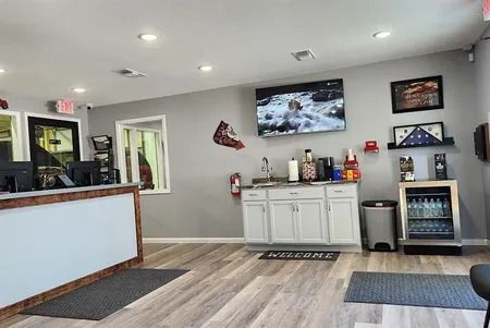 Bright reception area with white cabinets, wall-mounted TV, and wood-look flooring