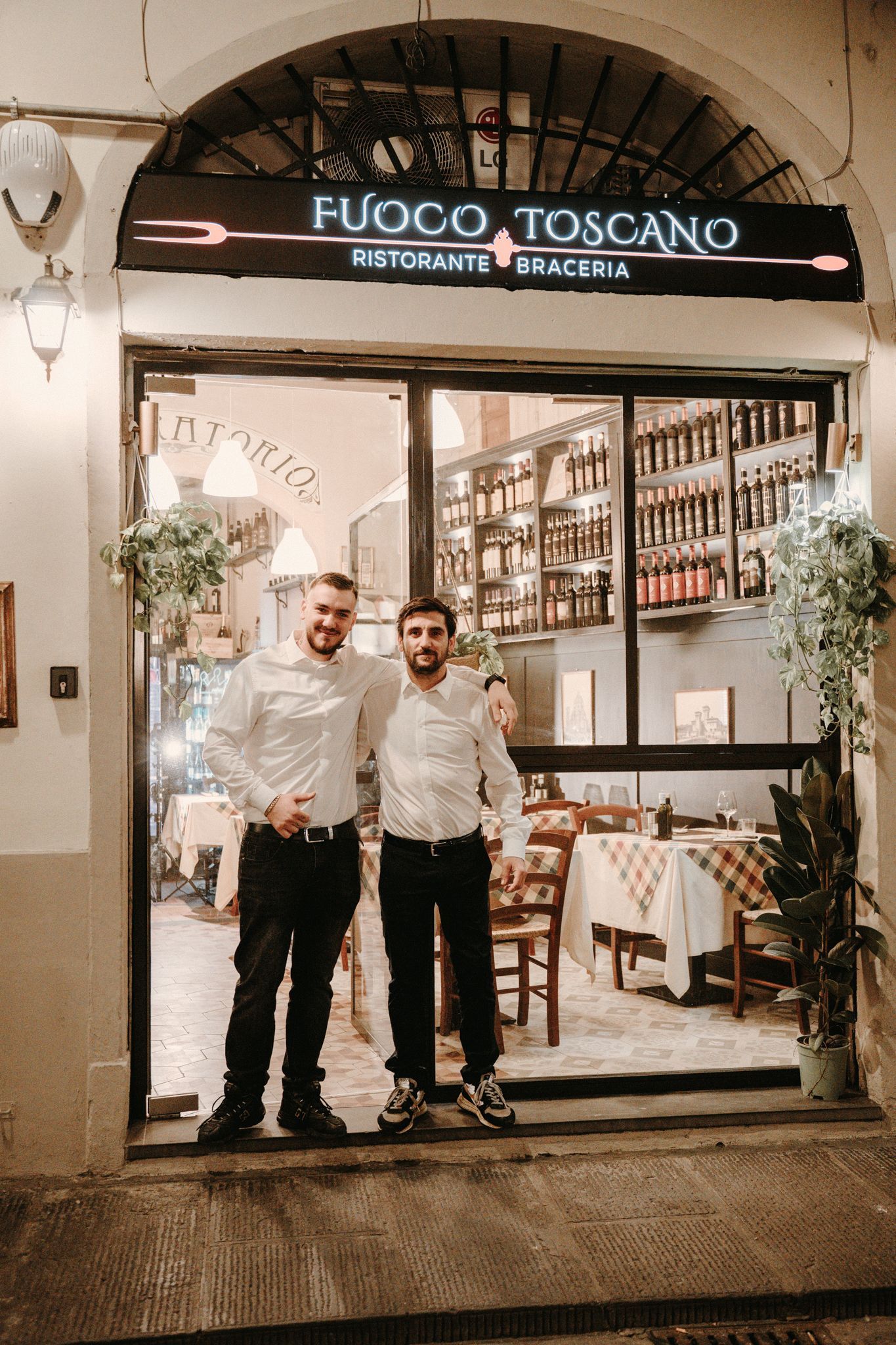 Due uomini sono in piedi sulla soglia del ristorante toscano