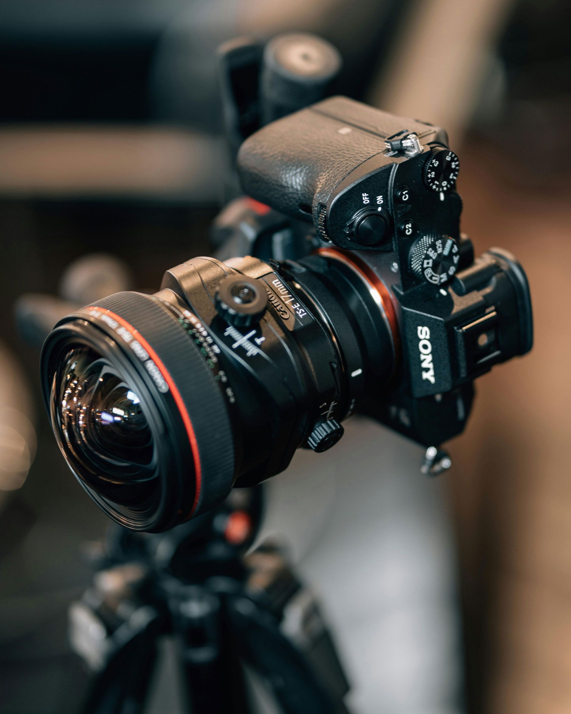 Un appareil photo hybride Sony monté sur un trépied avec un objectif grand angle volumineux.
