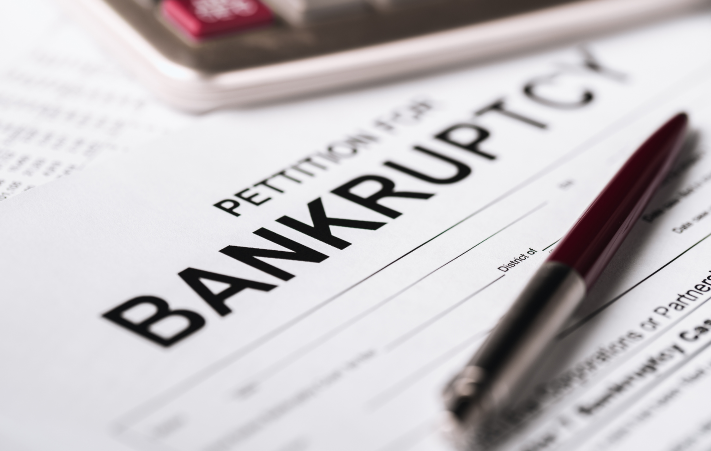 Petition for Bankruptcy document with pen and calculator.