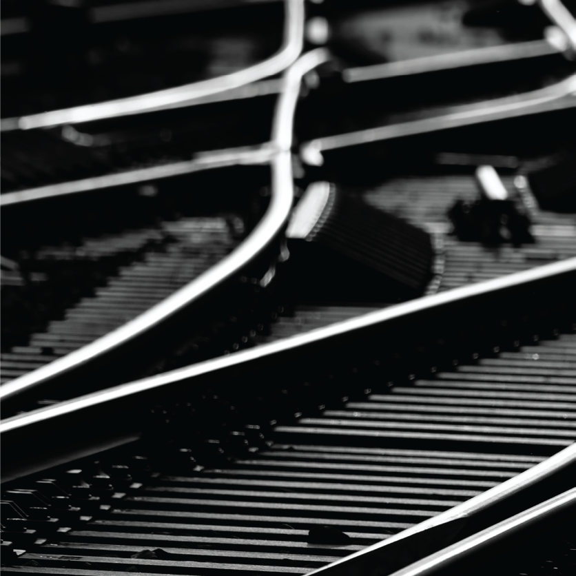 Close-up of black and white train tracks, curved and intersecting, with details of metal components.