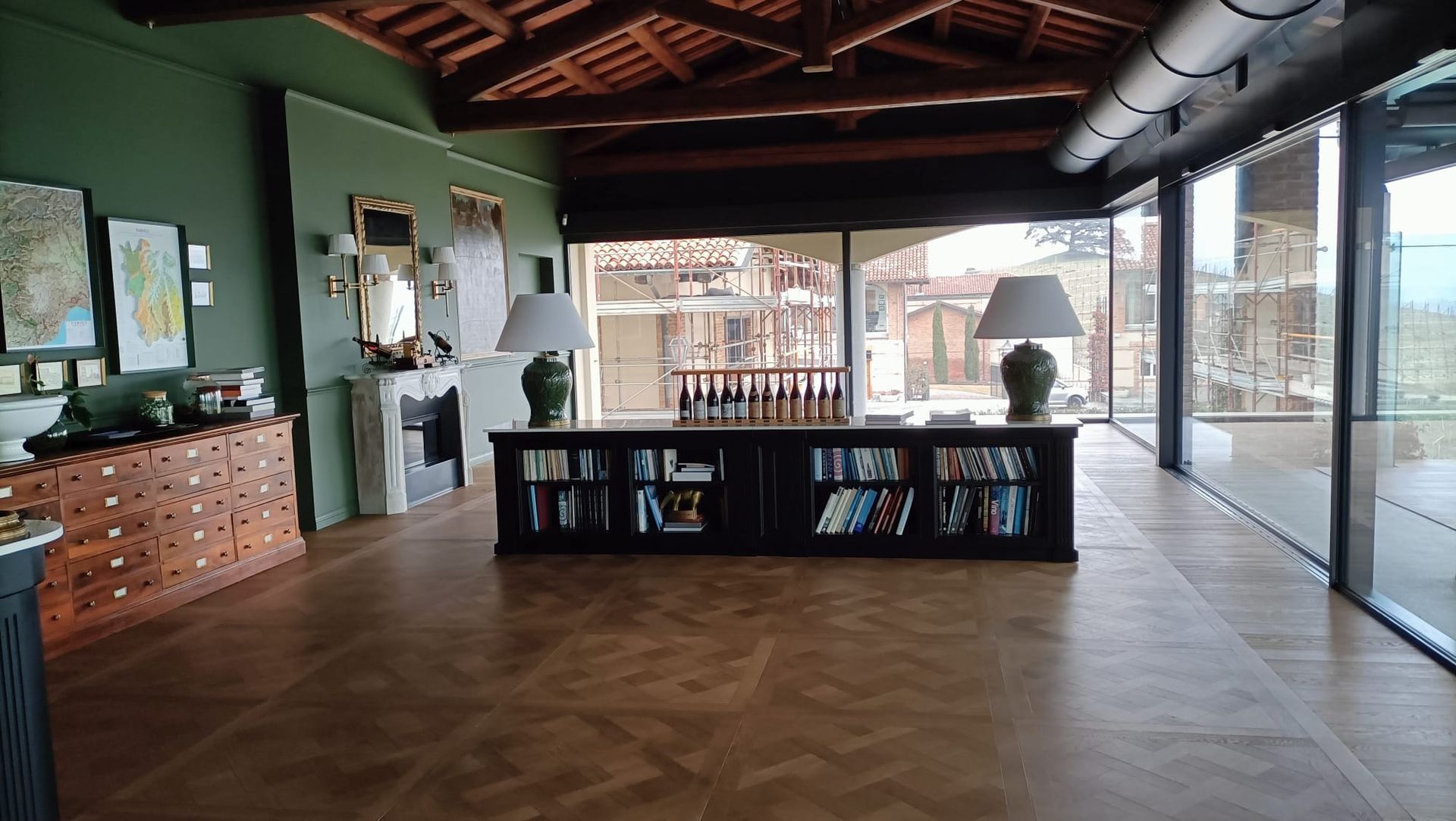 Soggiorno moderno con pavimento in legno, tavolino da caffè nero e ampie finestre che si affacciano su una terrazza.