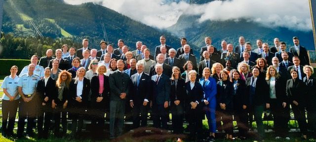 Eine große Gruppe von Menschen posiert für ein Foto mit Bergen im Hintergrund