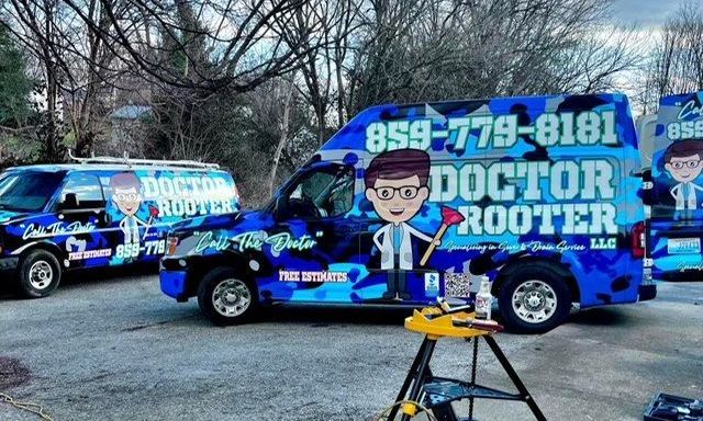 Three blue camouflage-wrapped vans labeled 