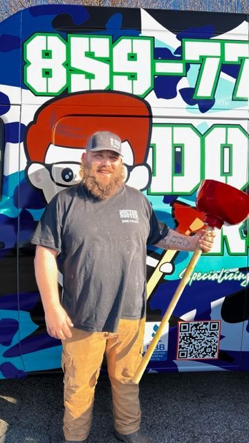 Man holding a mallet, standing in front of a colorful van with a logo and phone number.