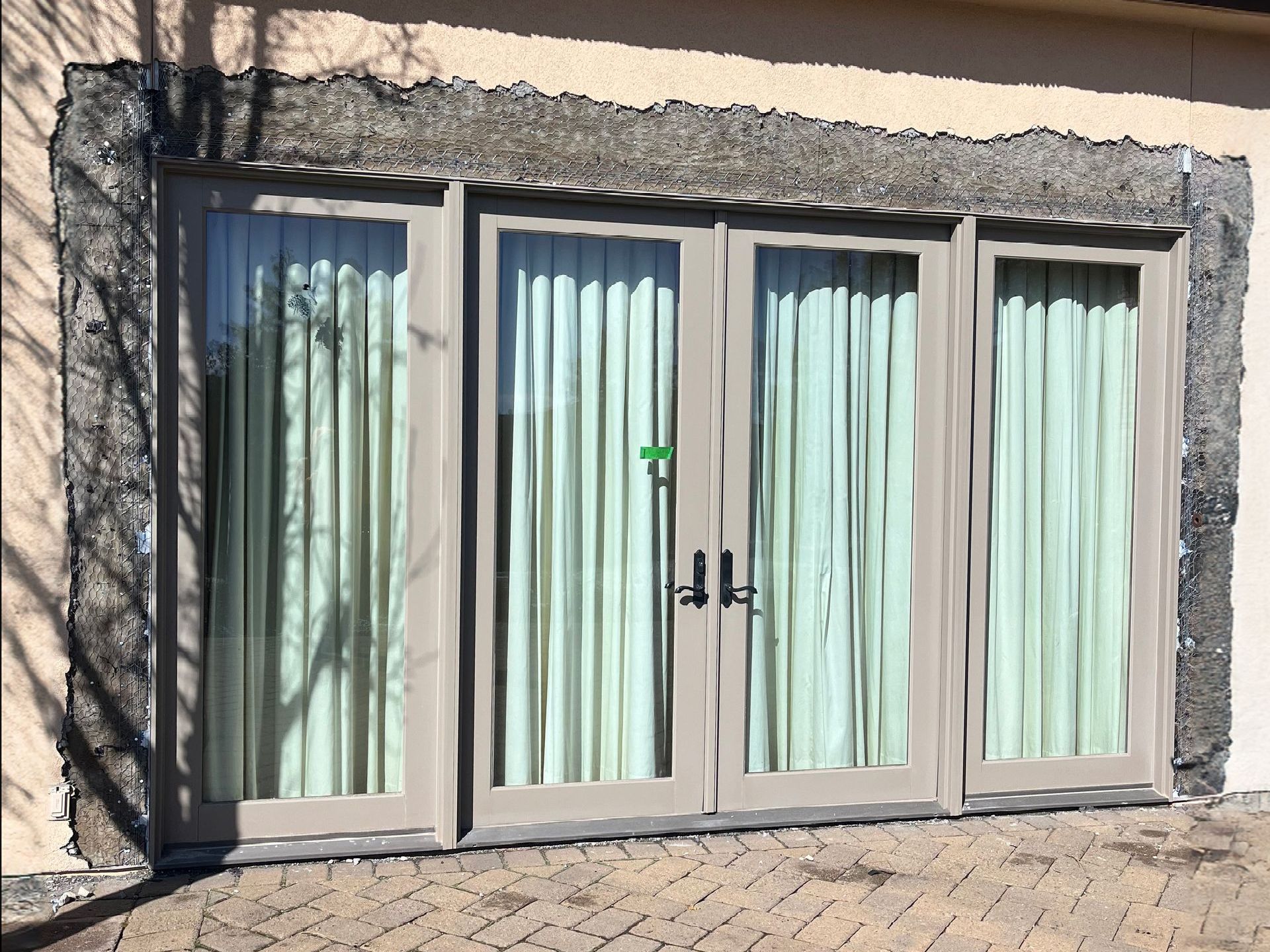 New french doors with stucco being repaired in Reno, Nevada.