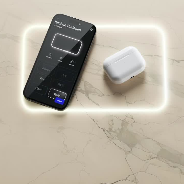 Black touchscreen phone and white wireless earbuds case glowing on a beige marble surface.