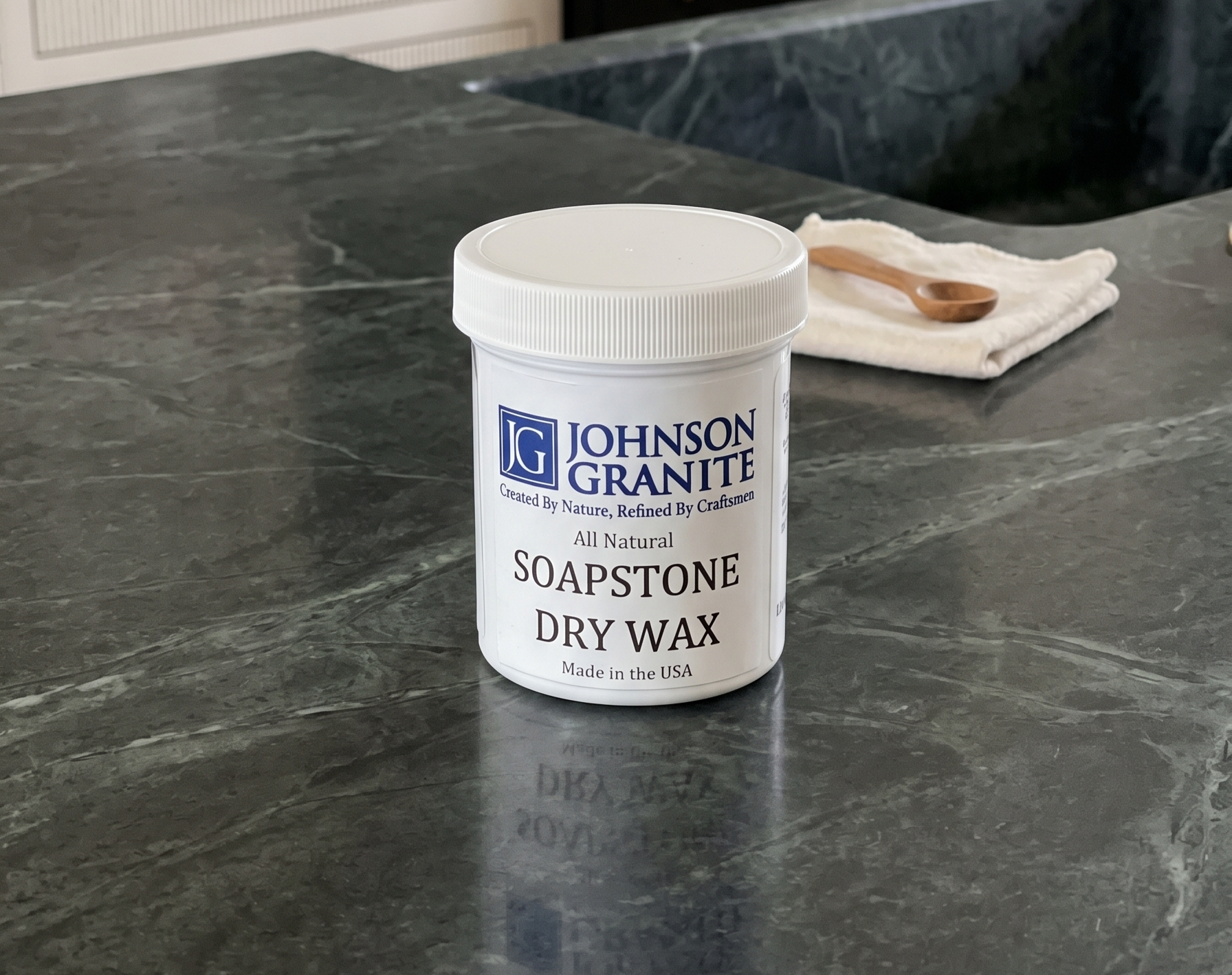 Johnson Granite Soapstone Dry Wax container on a dark stone countertop.