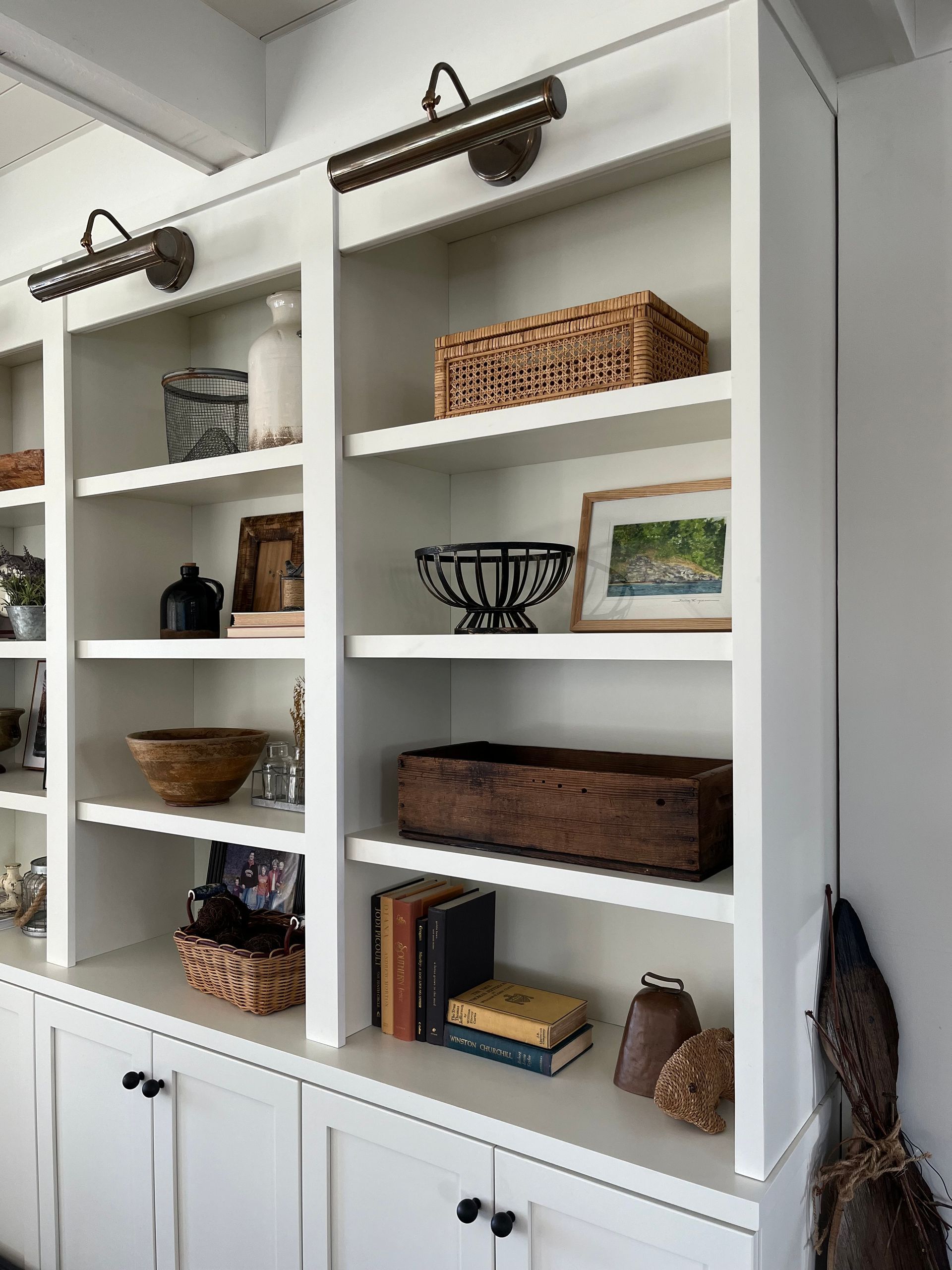 White built-in shelves with baskets, books, and decor in a bright room