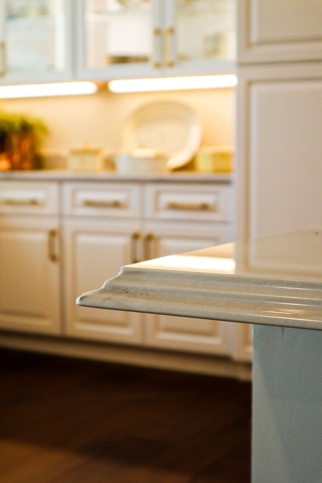Bright kitchen with white cabinets and a sunlit countertop in the foreground
