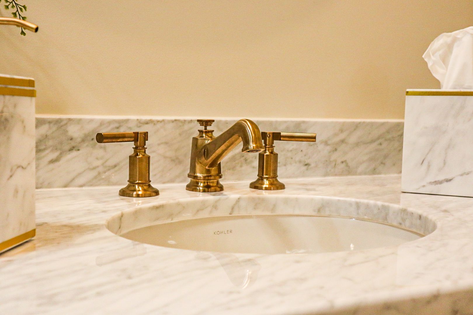 Marble bathroom vanity with oval sink and gold faucet fixtures
