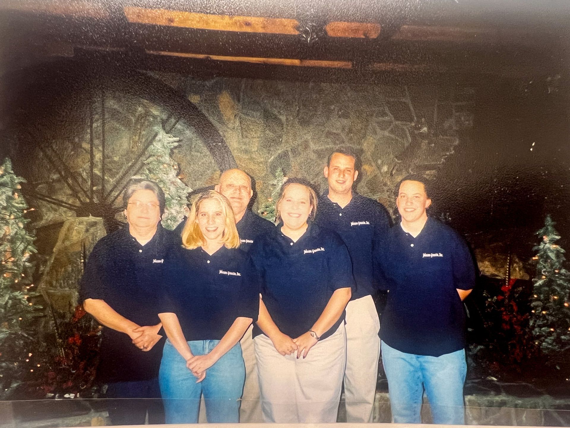 The Johnson family including Larry Johnson and his wife and children posing indoors in front of a stone wall and holiday decorations.