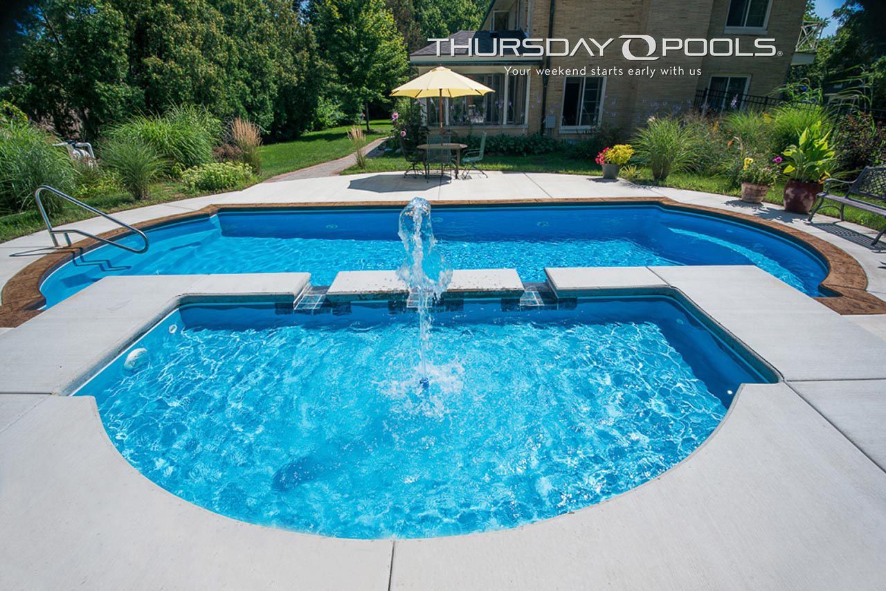 Blue backyard swimming pool with raised center fountain and landscaped garden patio