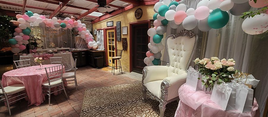 Pink and green bridal shower with custom cake and balloon garland and large throne with and silver chair at bexx secret garden.