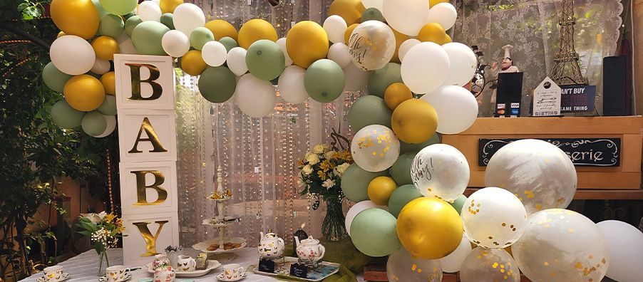 Baby Shower with large white BABY blocks with gold letters. surrounded by by gold, sage, white and clear balloon garland designed by bexx secret garden