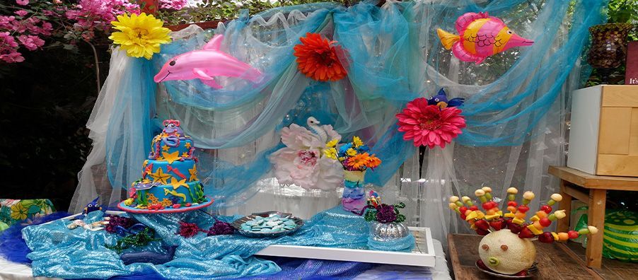 Bay's 1st birthday Under the Sea Dessert table with a custom tiered cake blue with a little purple and pink octopus on top with sea creatures blue cookies dolphins created by bexx in bexx secret garden