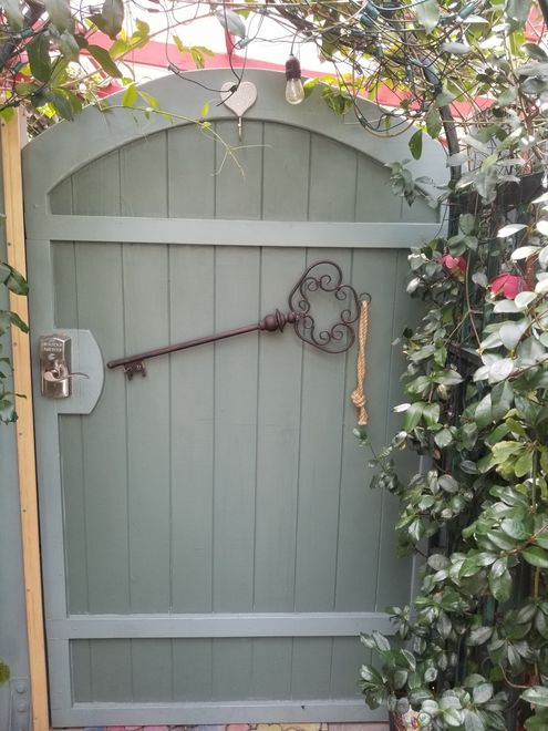 A wooden gate with a key hanging on it.