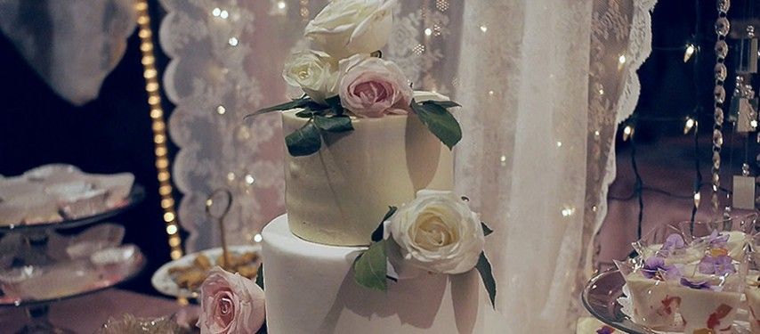 A wedding cake with flowers on it is on a table.
