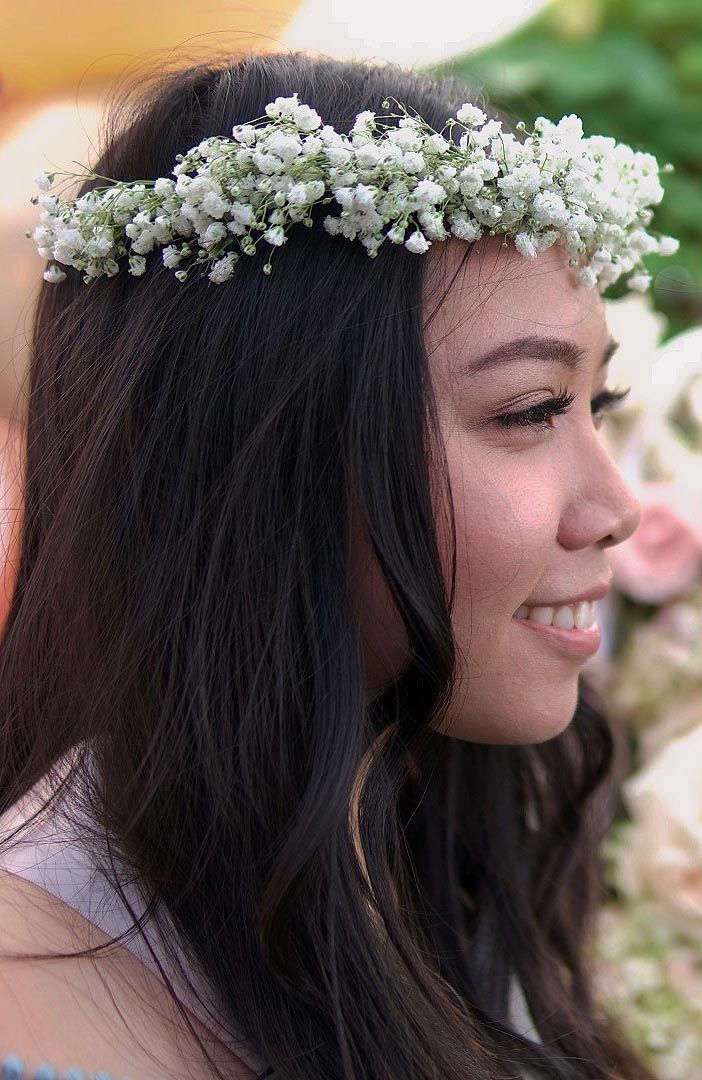 A woman is wearing a flower crown in her hair.
