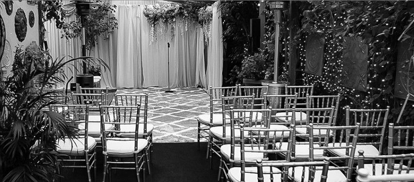 A black and white photo of a row of chairs lined up for a wedding ceremony.