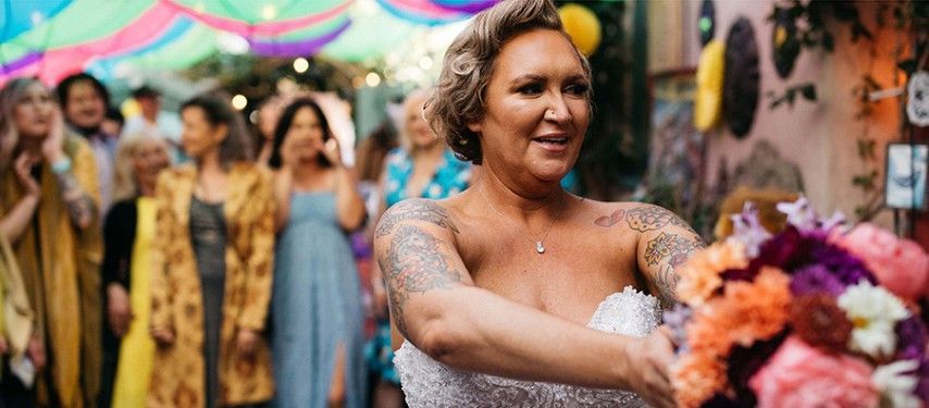 A woman in a wedding dress is holding a bouquet of flowers.