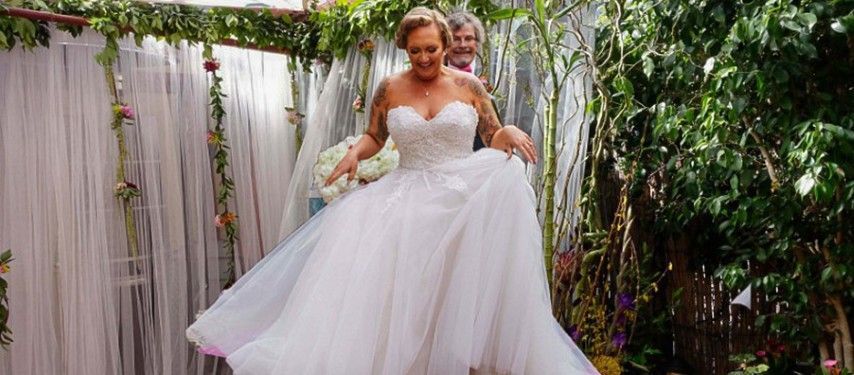 A bride in a wedding dress is walking down the aisle.