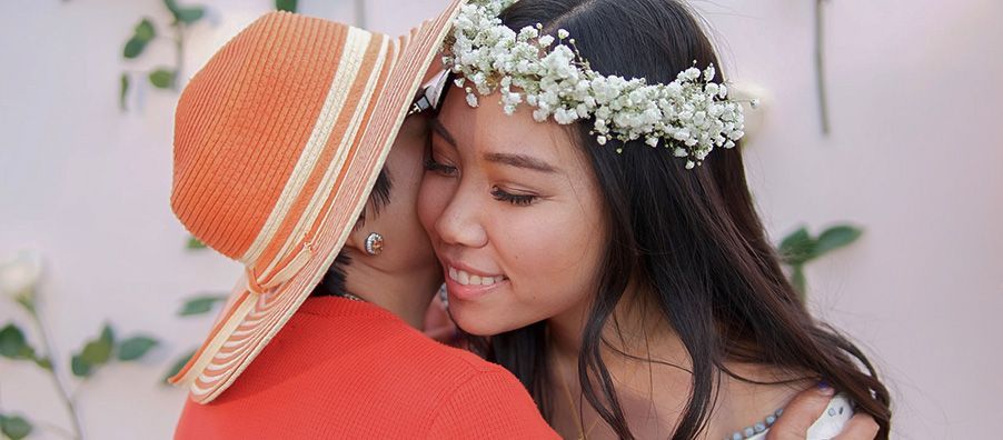 bride to be with flower crown hugging a guest.