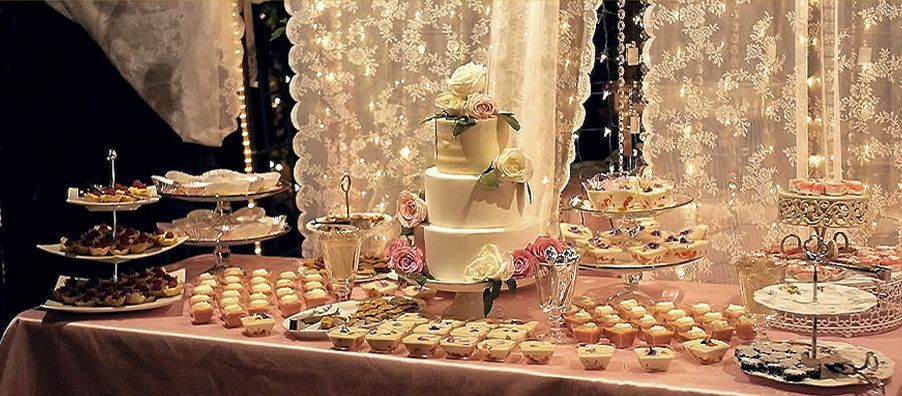 A table with a cake , cupcakes , and other desserts on it.