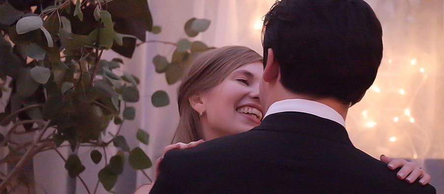 A bride and groom are dancing together at their wedding reception.
