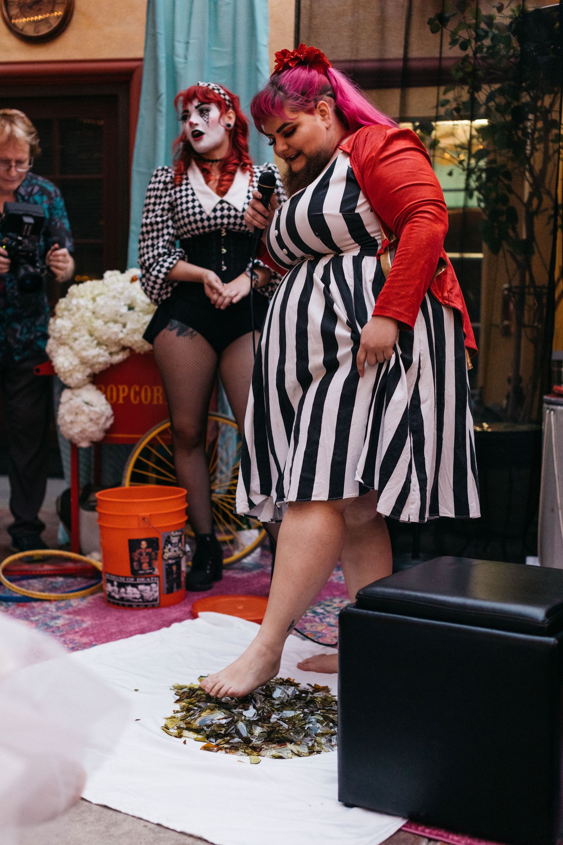A woman in a zebra print dress is standing on a table with a microphone.