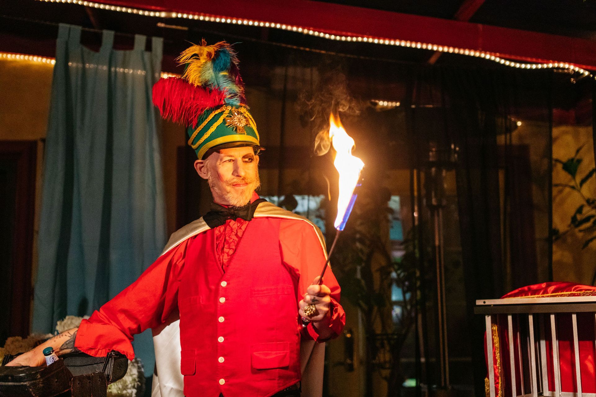 A man in a red jacket and hat is holding a fire torch.