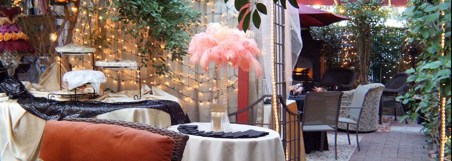 A table with a vase of pink feathers on it