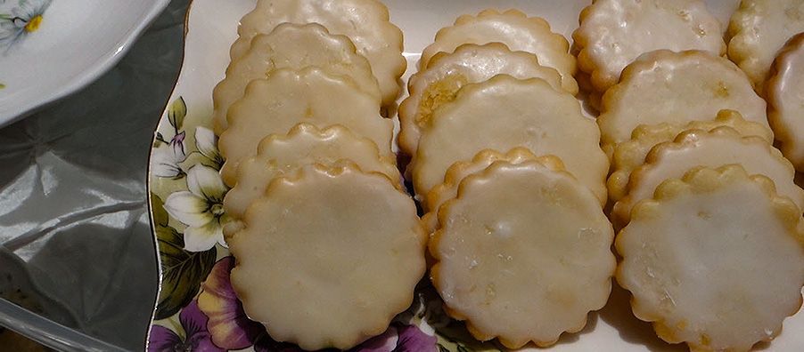 A plate of cookies with icing on them on a table.