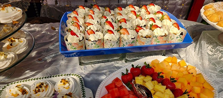 A table topped with a variety of desserts and fruit.