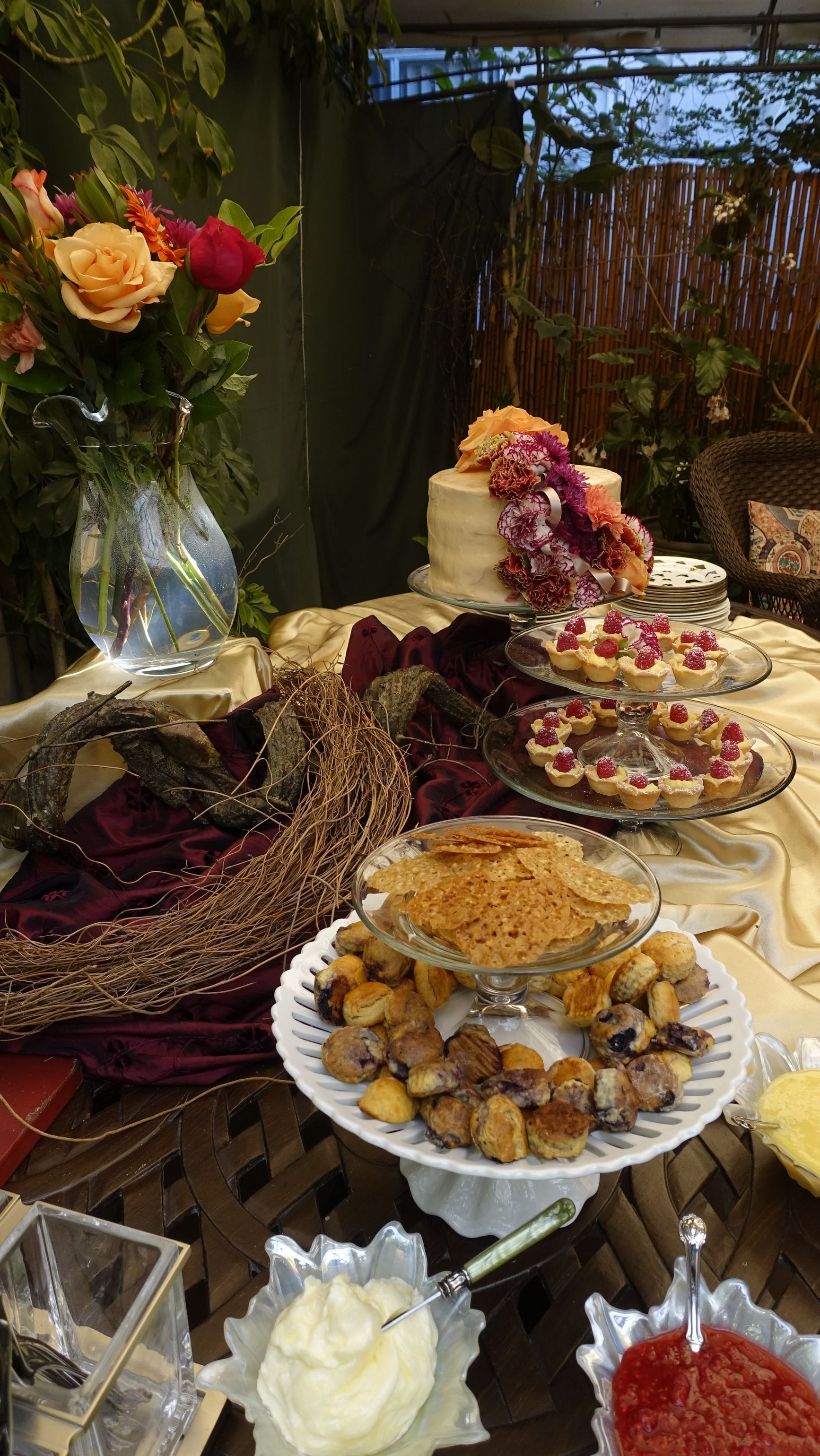 A table topped with plates of food and a vase of flowers.