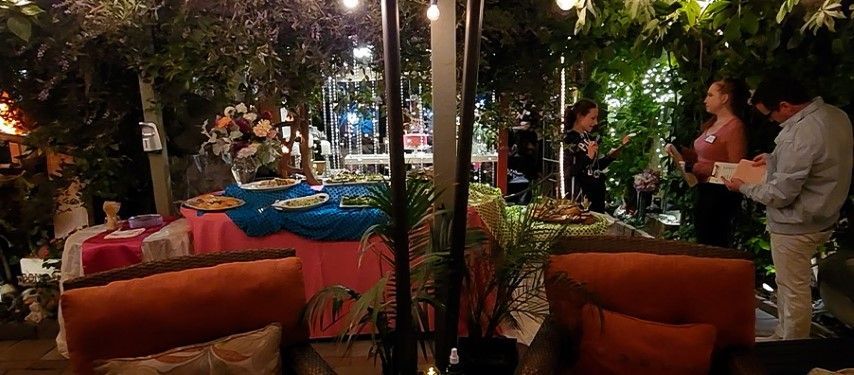 Guests working on Murder Mystery clues at party in bexx secret garden