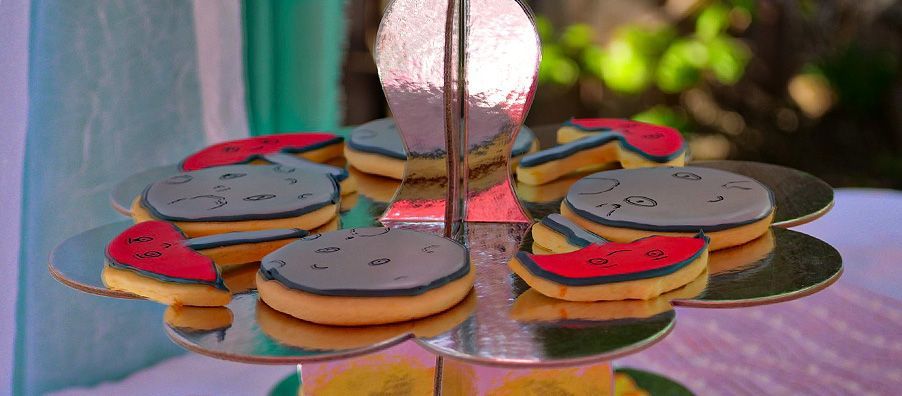 A display of cookies on a cupcake stand on a table.